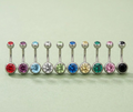 Row of belly buttons with colorful gemstones on a light green background